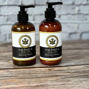 Two bottles of lotion sitting on top of a wooden table.