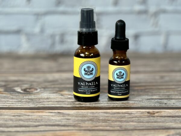 Two bottles of oil sitting on top of a wooden table.