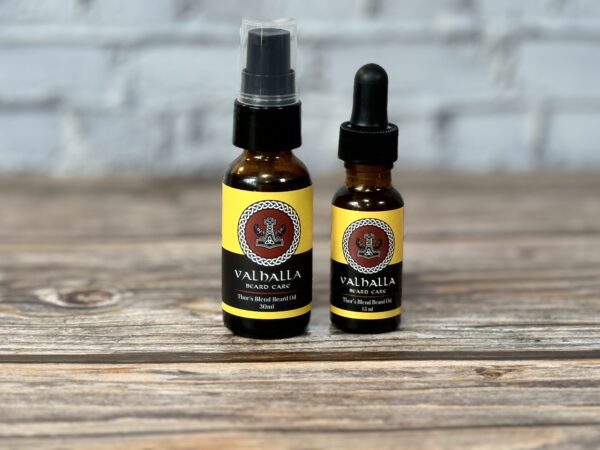 Two bottles of oil sitting on top of a wooden table.