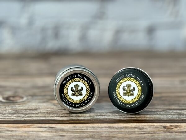 Two jars of lip balm sitting on top of a wooden table.