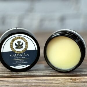 A couple of jars of balm sitting on top of a table.