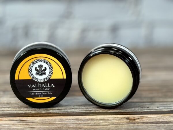 A couple of jars of lip balm sitting on top of a table.