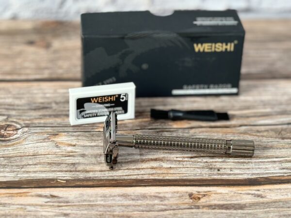 A razor and blade sitting on top of a wooden table.