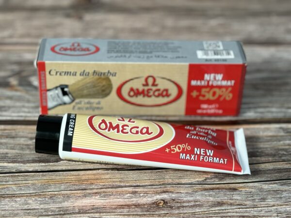 A tube of cream next to a box on top of a table.
