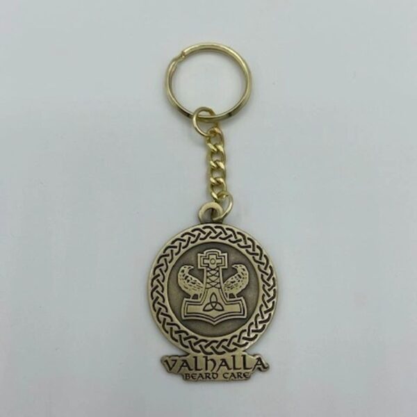 A gold key chain with a seal of valhalla on it.