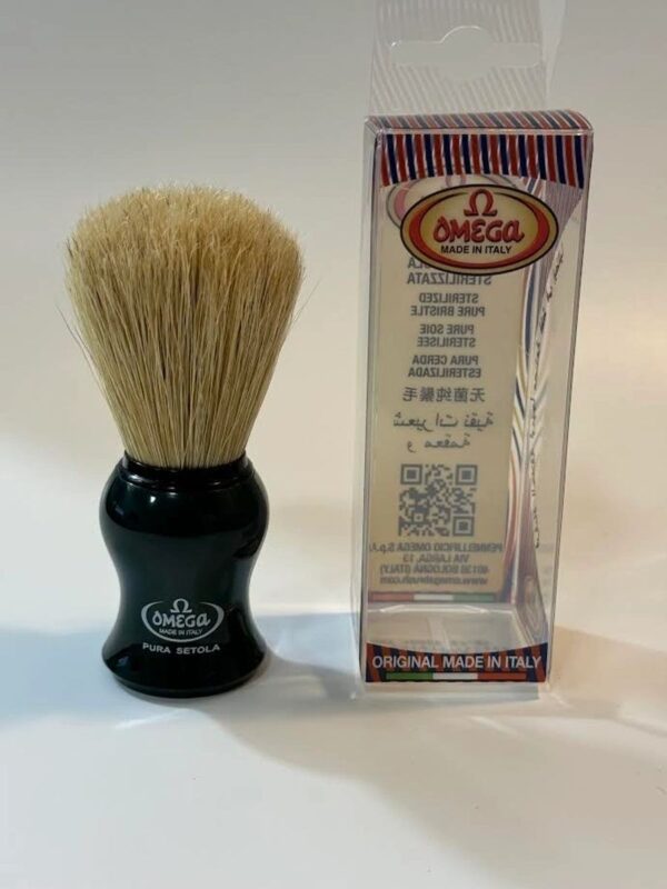 A black shaving brush next to its box.