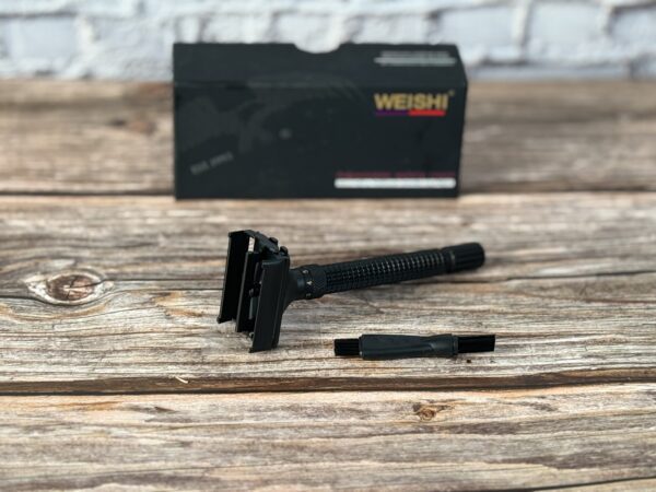 A razor is laying on the table next to its box.
