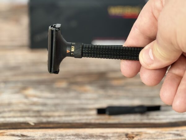 A person holding a razor blade in their hand.