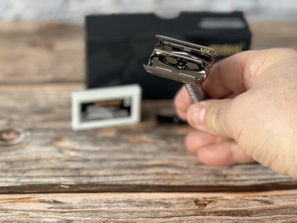 A person holding a razor blade in their hand.